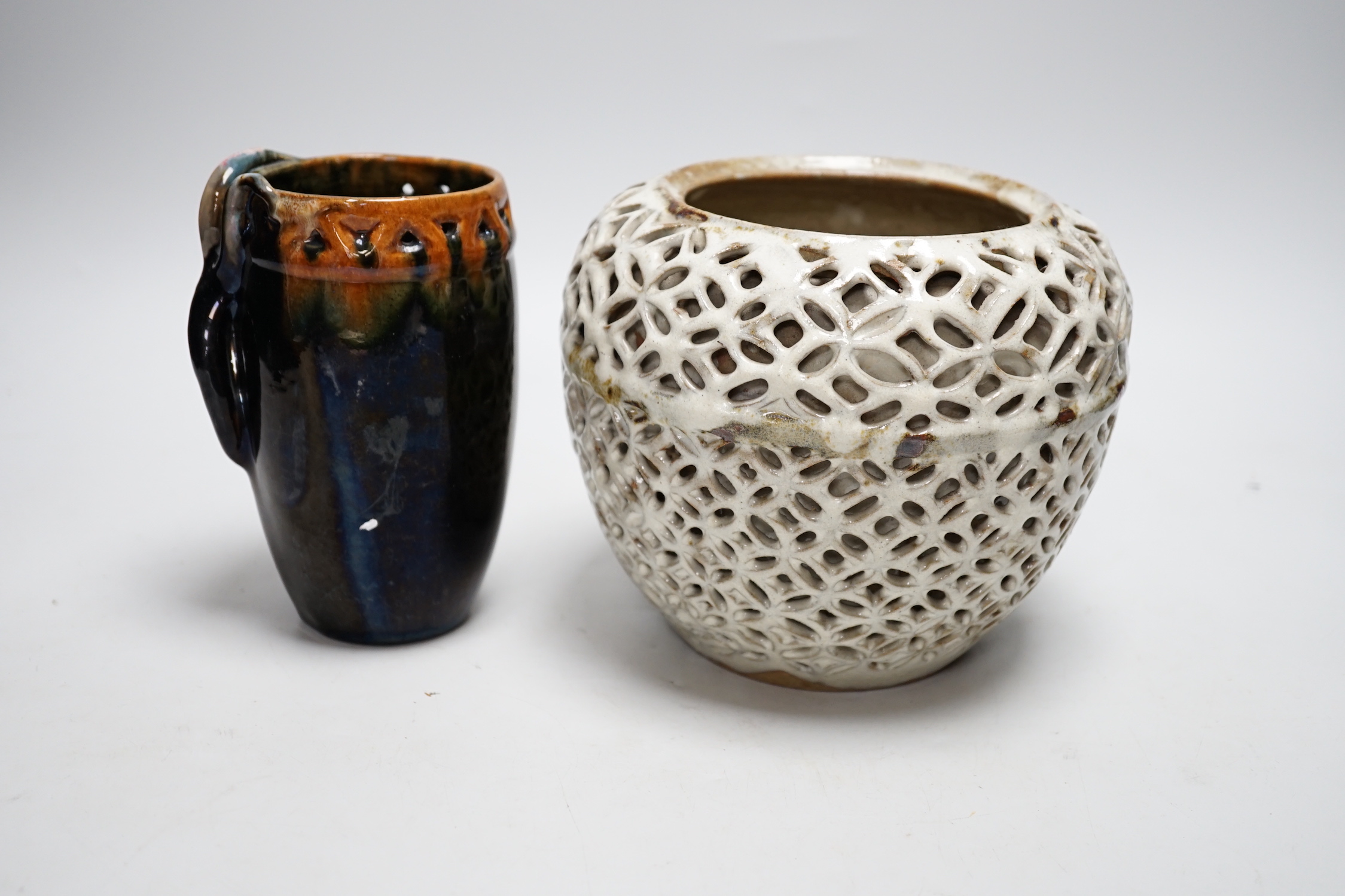 A reticulated art pottery vase and another pottery vase, largest 15cm high